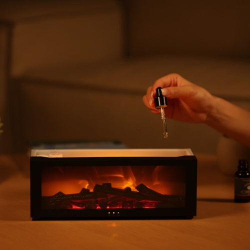 Flame effect aromatherapy diffuser on a desk beside books and warm ambient lighting